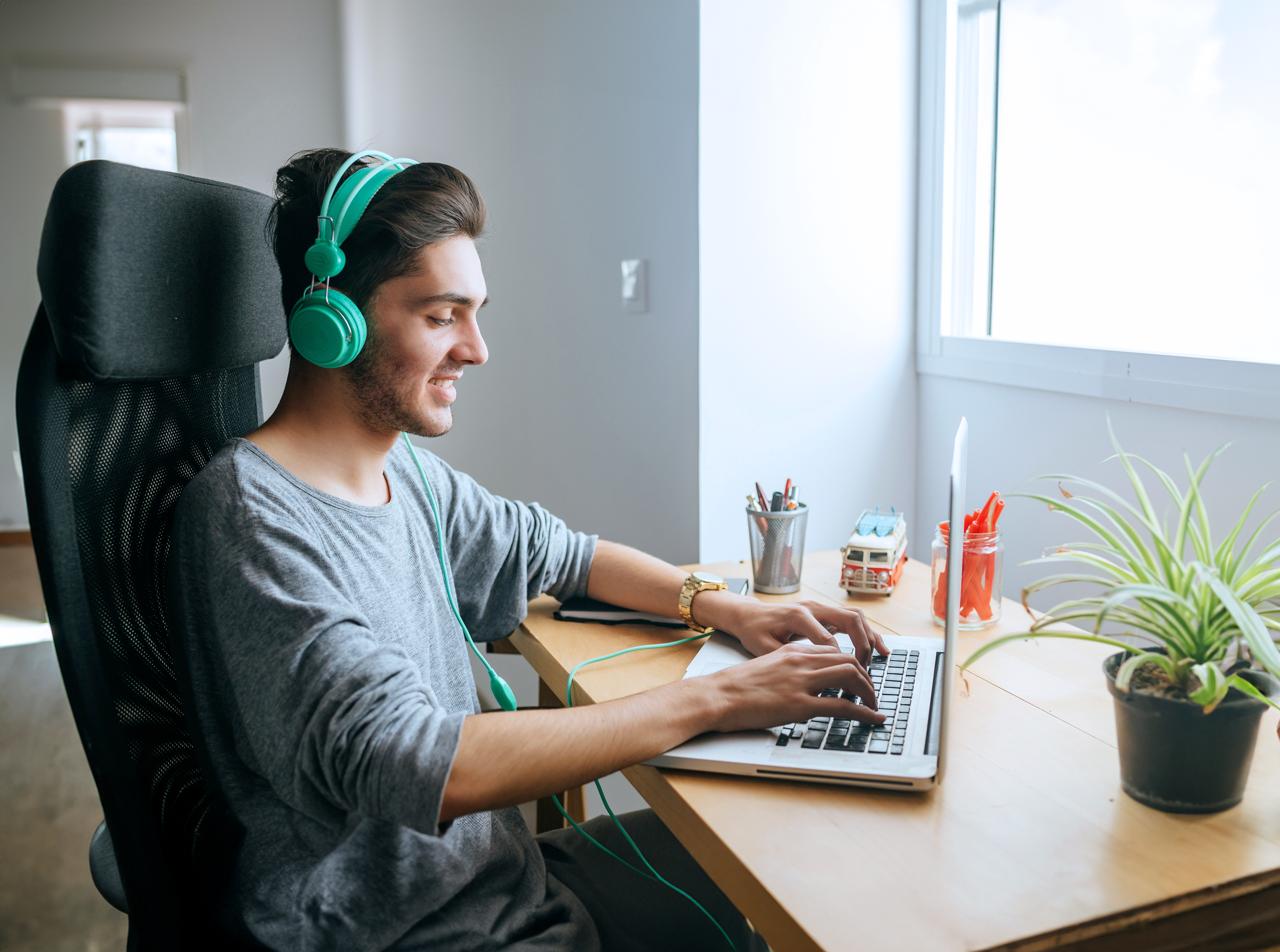 Young man using headphones and laptop at home